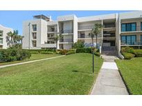 Exterior of condo building with lush landscaping and walkway at 50 Coe Rd # 322, Belleair, FL 33756