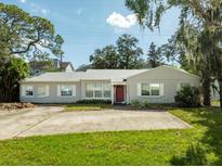 House exterior showcasing a ranch-style home with a red door and large yard at 4104 W El Prado Blvd, Tampa, FL 33629