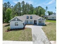 Charming single-story home boasts a manicured lawn and welcoming entrance with a lovely stone driveway at 4880 Hickory Oak Dr, Brooksville, FL 34601