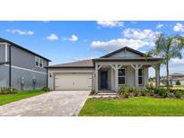 Charming single-Gathering home featuring a manicured lawn, two-car garage, and covered front porch at 13730 Evergreen Valley Dr, Riverview, FL 33578