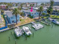 Waterfront home featuring two docks, boat lifts, lush landscaping, and spacious backyard at 241 Skiff Pt # 4, Clearwater Beach, FL 33767