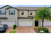 Two-story townhouse with attached garage and landscaping at 10012 Corso Milano Dr, Tampa, FL 33625