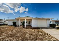 Mid-century ranch home with carport and landscaping at 1551 Derrick St, Holiday, FL 34690