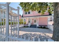 Charming pink house with white picket fence and gravel driveway at 963 Highland Ave, Dunedin, FL 34698
