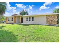 Ranch style home with stone accents and a well-maintained lawn at 701 Madison Sw St, Ruskin, FL 33570