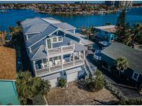 Stunning aerial view of waterfront home with private dock and beautiful landscaping at 10045 Gulf Blvd, Treasure Island, FL 33706