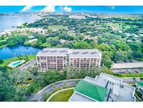 Aerial view of a condo building with pool and waterfront access at 220 Belleview Blvd # 802, Belleair, FL 33756