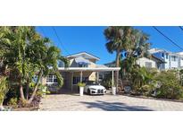 Two-story house with striped awning and tropical landscaping at 13319 Boca Ciega Ave, Madeira Beach, FL 33708