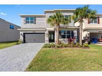 Beautiful two-story home boasting an attached garage, palm trees, and manicured front lawn at 32707 Tamarind Grove Ln, Wesley Chapel, FL 33543