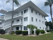 Two-story building with white exterior, featuring balconies and landscaping at 11201 80Th Ave # 201, Seminole, FL 33772