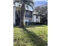 Two-story condo building with balconies and lush landscaping at 2688 Pine Ridge N Way # D1, Palm Harbor, FL 34684