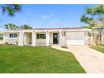 Charming single-story home features a stone facade, attached garage, and a well-manicured lawn at 7623 Rottingham Rd, Port Richey, FL 34668