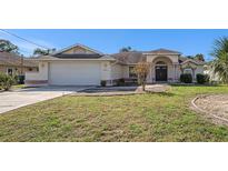 One-story home with a two-car garage and manicured lawn at 2057 Carson Ave, Spring Hill, FL 34608