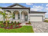Charming single-story home with a covered front porch, paver driveway, and well-maintained landscaping at 1650 Fallon Pass, Zephyrhills, FL 33541