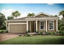 Tan one-story house with a two-car garage and landscaping at 11720 Renaissance Blvd, Venice, FL 34293