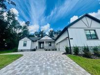 Charming single-story home featuring a brick driveway and modern farmhouse architecture at 4000 Southern Valley Loop, Brooksville, FL 34601