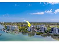 Aerial view of waterfront condo building with boat slips and lush landscaping at 8 Belleview Blvd # 408, Belleair, FL 33756