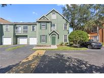 Two-story townhome with green exterior and driveway at 9650 Lake Chase Island Way # 9650, Tampa, FL 33626