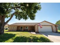 Charming one-story brick home featuring a well-maintained lawn and mature shade tree at 12210 Buttonwood Row, Hudson, FL 34667