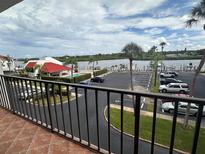 Condo balcony overlooking a parking lot and waterfront view, offering a glimpse of the waterway at 19111 Vista Bay Dr # 308, Indian Shores, FL 33785