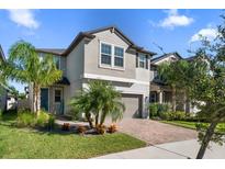 Two-story house with gray siding and a brick driveway at 8593 Winning Fields Rd, New Port Richey, FL 34655