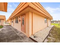 Exterior view of light orange house with walkway at 1801 Bedford Ln # 27, Sun City Center, FL 33573