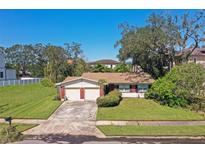 Brick ranch house with two-car garage and yard at 5007 W Dickens Ave, Tampa, FL 33629