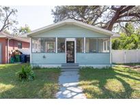 Charming light blue bungalow with a screened porch and well-maintained lawn at 3405 E 33Rd Ave, Tampa, FL 33610
