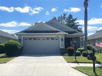 Single-story home with two-car garage and landscaped yard at 18833 Bent Pine Dr, Hudson, FL 34667