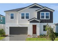 Two-story house with neutral siding, dark brown accents, and a red door at 10341 Fieldstone Myrtle Way, San Antonio, FL 33576