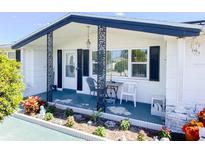 Charming single story home with a covered porch and well-manicured landscaping at 1516 Roundtree Rd, Holiday, FL 34690