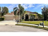 Two-story house with a two-car garage and palm trees at 10411 Riverburn Dr, Tampa, FL 33647
