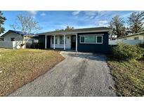 A charming bungalow with a gray exterior and a gravel driveway at 1882 Maryland Ne Ave, St Petersburg, FL 33702