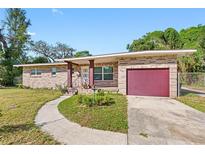Brick ranch house with a red garage door and landscaped yard at 404 E Morgan St, Brandon, FL 33510