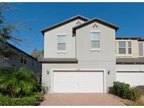 Two-story house with white garage door and brick driveway at 10038 Corso Milano Dr, Tampa, FL 33625