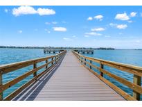 Scenic view of a wooden dock extending into the calm blue waters under a partly cloudy sky at 5200 Brittany S Dr # 1202, St Petersburg, FL 33715