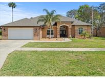 Single-story home with two-car garage and landscaped yard at 14173 Pullman Dr, Spring Hill, FL 34609