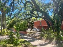 Two-story coral home with lush landscaping and driveway at 817 S West Shore Blvd, Tampa, FL 33609