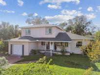 Cute two-story house with a large front yard, covered porch, and a two-car garage at 2709 17Th S St, St Petersburg, FL 33712