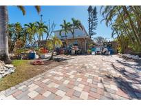 Brick paved front yard with tropical landscaping at 14180 W Parsley Dr, Madeira Beach, FL 33708