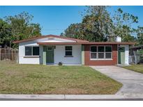 Newly renovated home with a modern exterior, featuring a green door and brown accents at 1328 Barry St, Clearwater, FL 33756