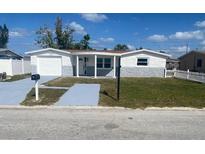 Charming single-story home featuring a light gray and white exterior with a well-manicured front yard at 4803 Guardian Ave, Holiday, FL 34690