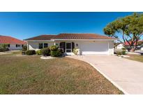 Charming single-story home featuring a tile roof, attached garage, and well-manicured front yard at 701 Westmont Way, Sun City Center, FL 33573