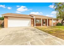 Single story home with a two car garage and porch at 5621 Moog Rd, New Port Richey, FL 34652