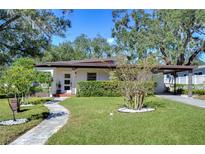 Mid-century modern home with landscaped yard and walkway at 1802 E Hamilton Ave, Tampa, FL 33610