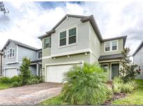 Two-story home with gray siding and a white garage door at 9612 Little Bluestem Dr, Land O Lakes, FL 34637