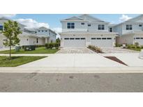 Charming two-story townhome with two-car garage and a well manicured lawn and blue skies at 31895 Anchor Point Dr, Wesley Chapel, FL 33545