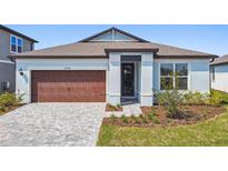 Charming single-story home featuring a brown garage door and well-manicured front yard at 6741 Michael Favor Way, Wesley Chapel, FL 33545
