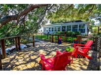 Wooden deck with red Adirondack chairs, ideal for enjoying the view at 10931 Clara Ln, St Petersburg, FL 33708