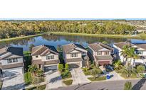 Aerial view of five houses near a lake, showcasing a desirable community setting at 7779 Yale Harbor Dr, Wesley Chapel, FL 33545